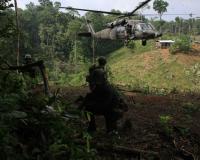 Policía Antinarcóticos  stand on guard after burning a coca laboratory near Tuma