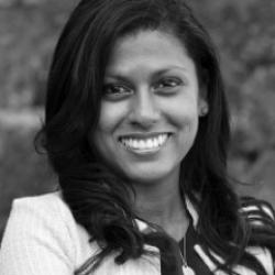 A smiling woman in a white blazer 