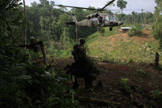 Policía Antinarcóticos  stand on guard after burning a coca laboratory near Tuma