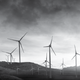 white wind turbines against a cloudy sky