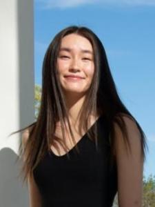 An image of an Asian woman in a black dress, smiling